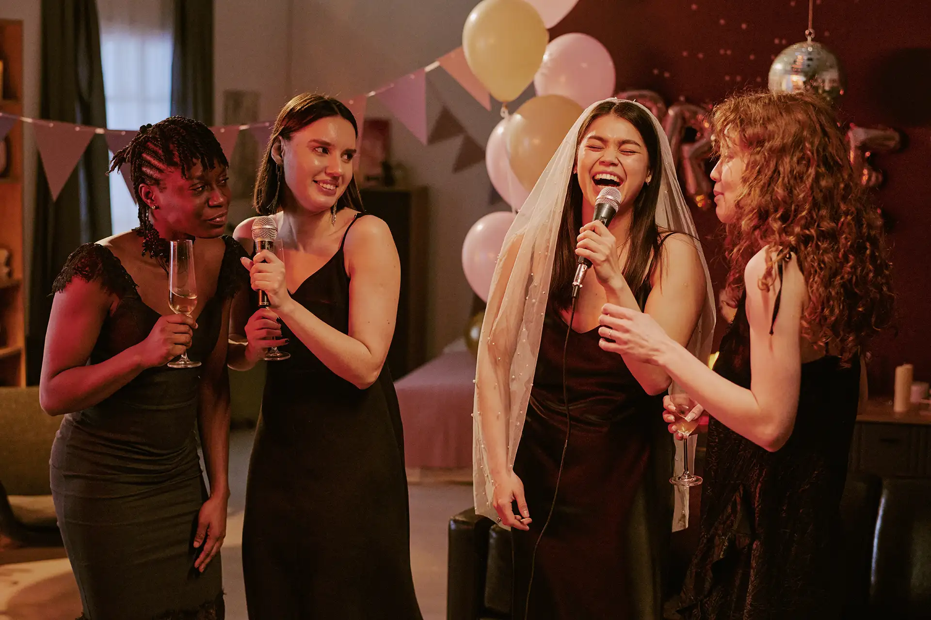 Women celebrating at a party with champagne and microphones